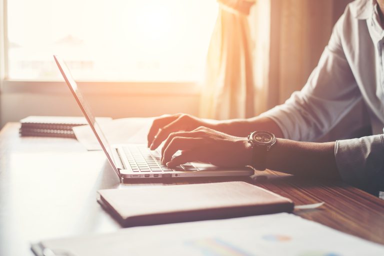Close-up of male hands using laptop in home