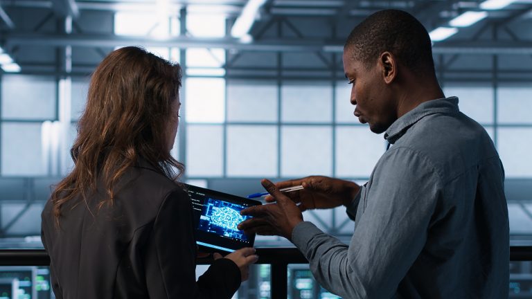 Teamworking server farm employees using AI on tablet